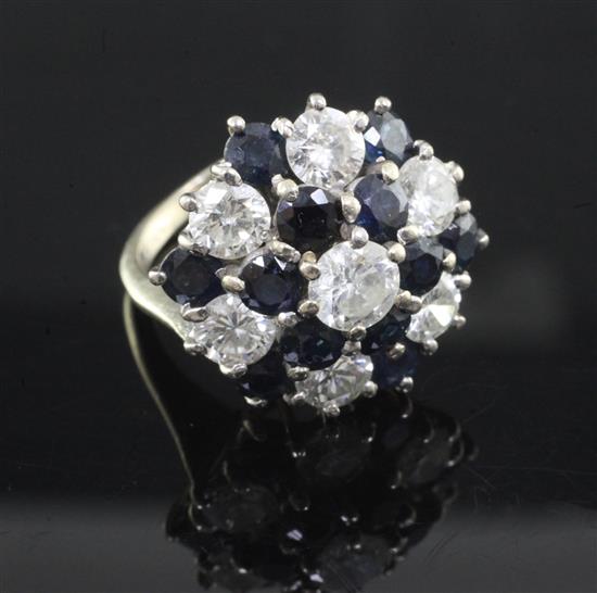 A diamond and sapphire cluster ring, set with seven brilliant cut diamonds and twelve sapphires, 18ct white gold shank, size J/K.